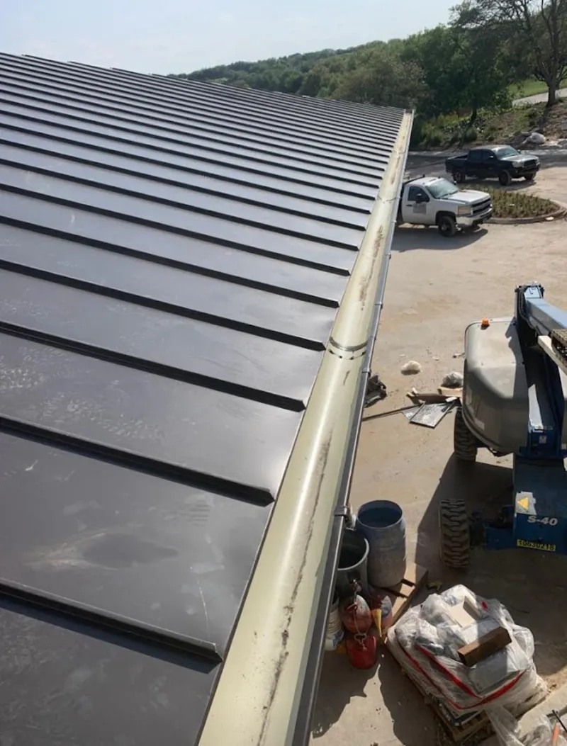 Standing seam panel and gutter detail on a metal roofing jobsite in Pleasant Garden